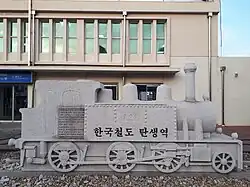 An outdoor plaque of a steam engine commemorating the birth of Korean rail