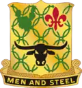 A Gold color metal and enamel device 1+1⁄8 inches (2.9&nbsp;cm) in height overall consisting of a shield blazoned: Or, chain mail Vert, in chief a prickly pear cactus of the last and a fleur-de-lis Gules and in base a carabao affronté Sable. Attached below and to the sides of the shield a Black scroll turned Gold inscribed "MEN AND STEEL" in Gold letters.