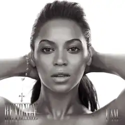 The cover of the album "I Am... Sasha Fierce" features a black and white profile of Beyoncé. She is looking directly to the camera while she keeps her hands behind her head. Her hair is combed with a ponytail, and she wears a bracelet on her right wrist. At the lower left corner her first name is written in capital silver letters, while "I Am..." is written with the same pattern at the right corner.