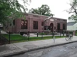 Roosevelt Library, a small Tudor Revival building surrounded by a neat lawn and black fence